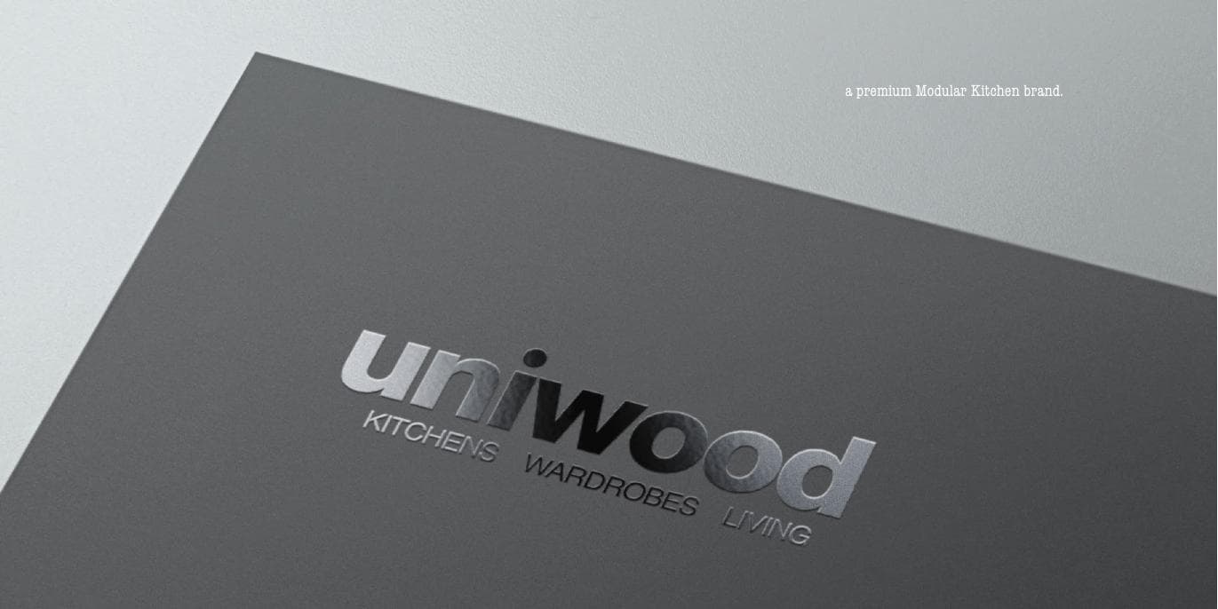 The Uniwood wordmark pressed in silver foil on charcoal stock.